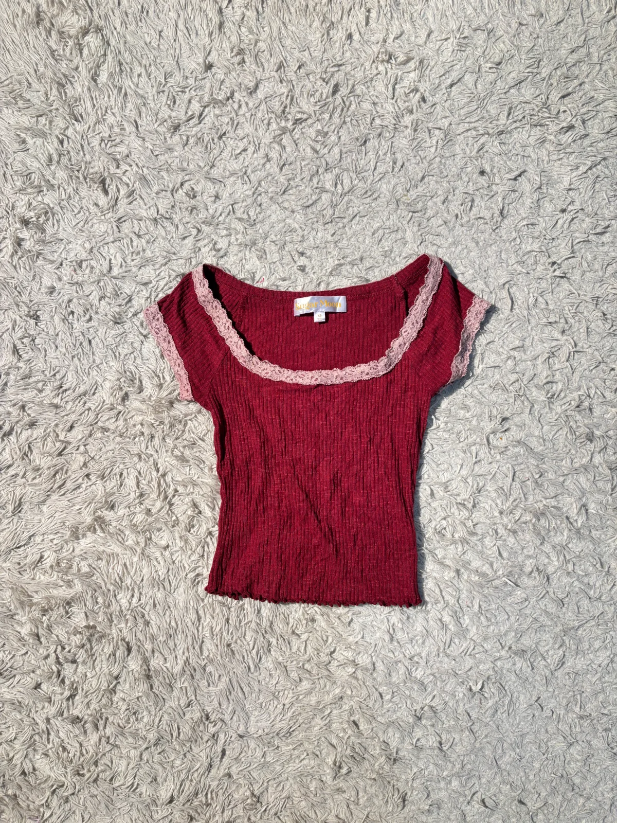 burgundy ribbed top with a square neckline trimmed with light pink lace.