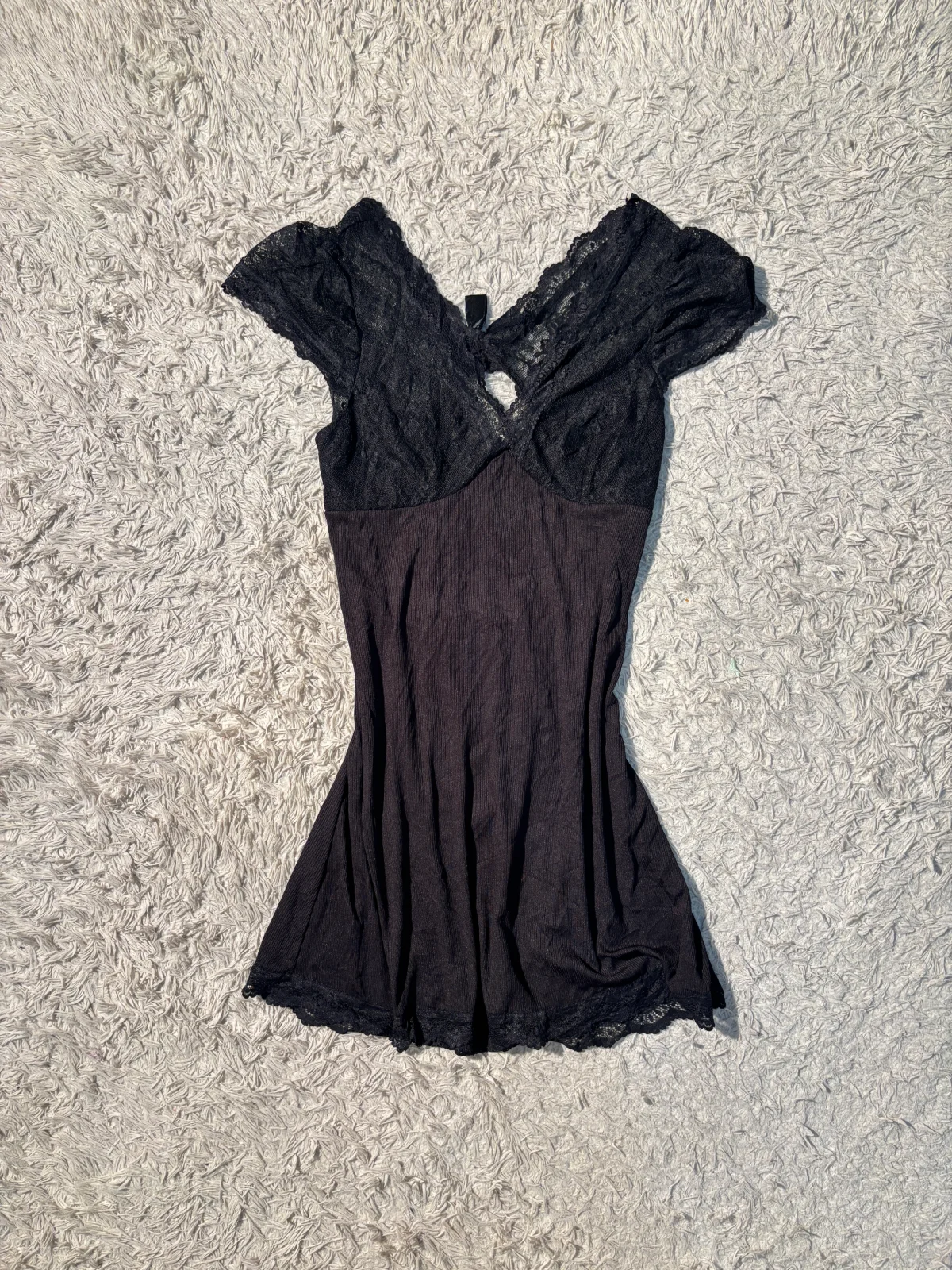black babydoll dress features delicate lace detailing on the bodice and ruffled cap sleeves with open back — view 1