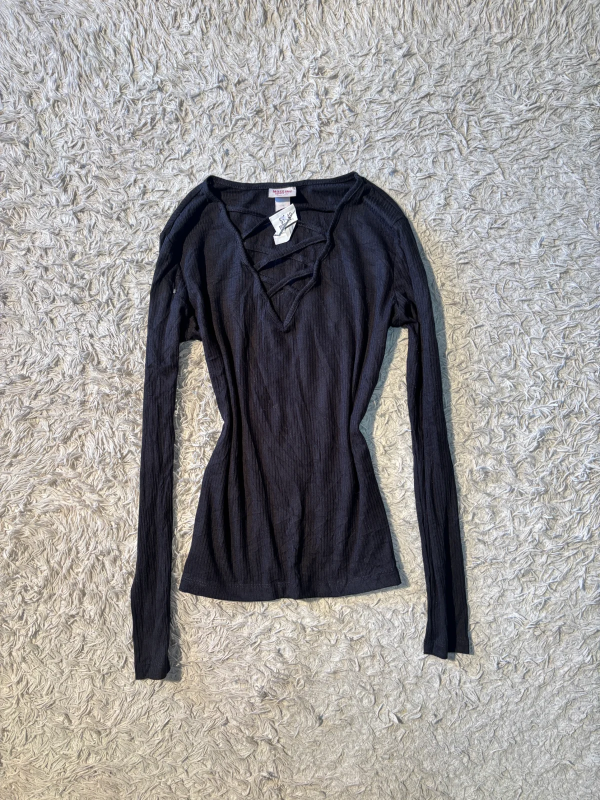 black long-sleeve top with a distinctive crisscross V-neck design.