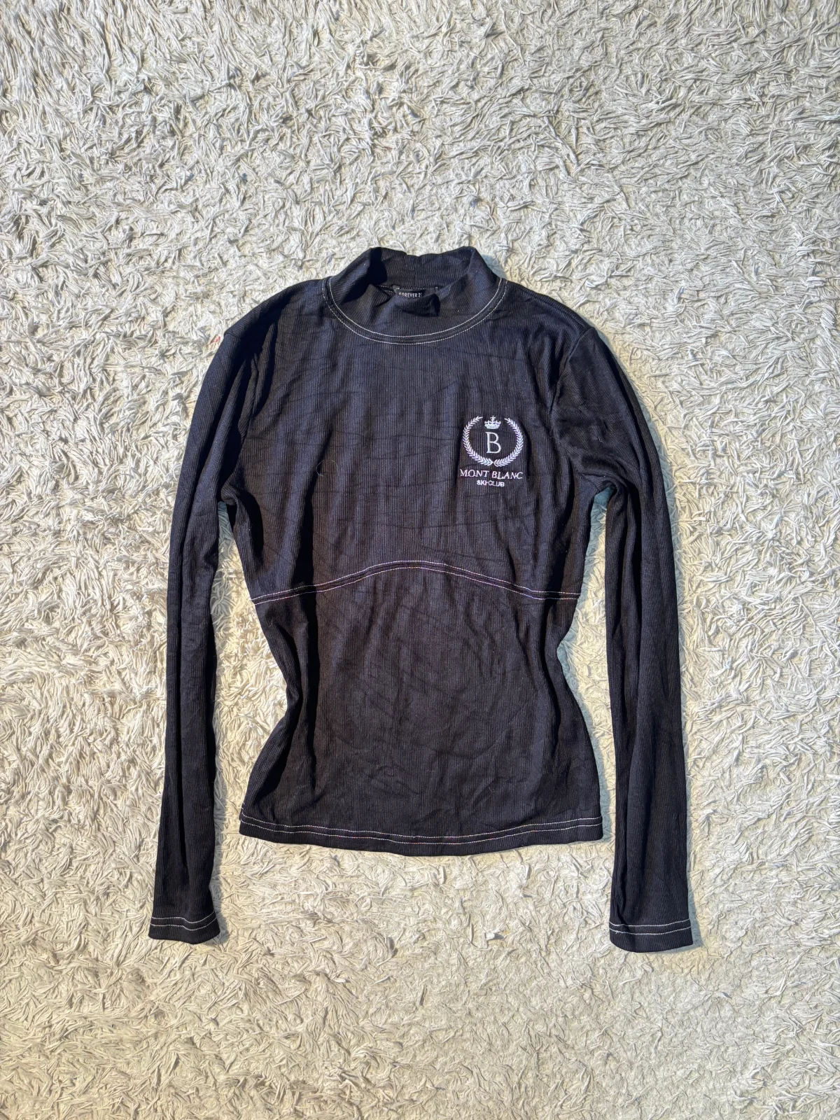 black ribbed mock neck long-sleeve top featuring a white “MONT BLANC” graphic logo 